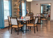 Thumbnail 5 of 7 - A dining room with a table and chairs.