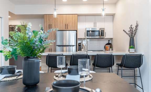 A modern dining room with a table set for six.at Vibe Apartments at Arbour Lake, Calgary, AB T3G 4J2