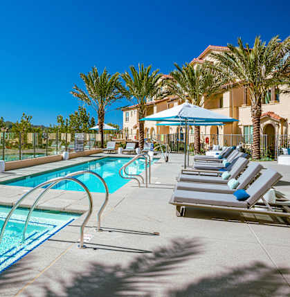 A pool with a slide and sun loungers.