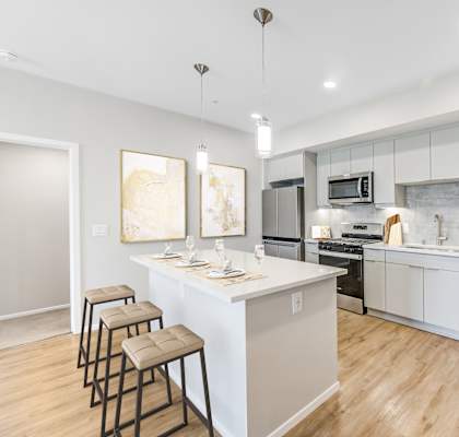 A modern kitchen with a bar area and stools.