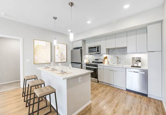 A modern kitchen with a bar area and stools.