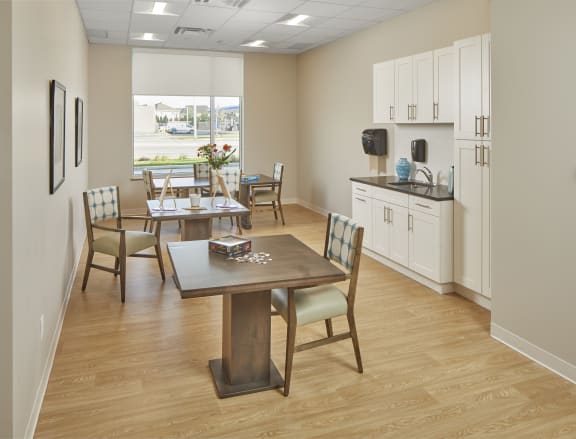 A dining room with a table and chairs and a kitchenette