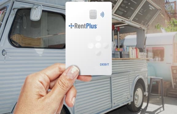 a person holding a rental bus card in front of a van