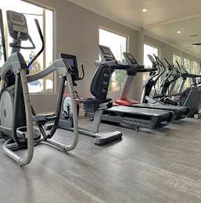 A gym with treadmills and elliptical machines at Sharlands Terrace Apartments, Apartments, Reno, NV