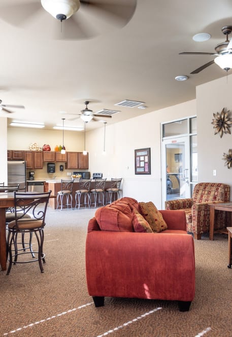 a living room with a red couch and a kitchen with a table and chairs