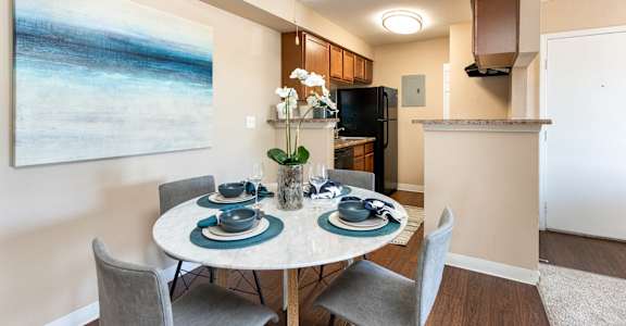 A dining room with a table set for four.