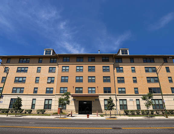 A large building with a flat roof and a red door in front.