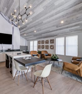 a living room with a dining room table and chairs and a kitchen with a tv
