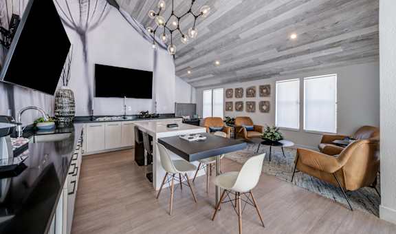 a living room with a dining room table and chairs and a kitchen with a tv