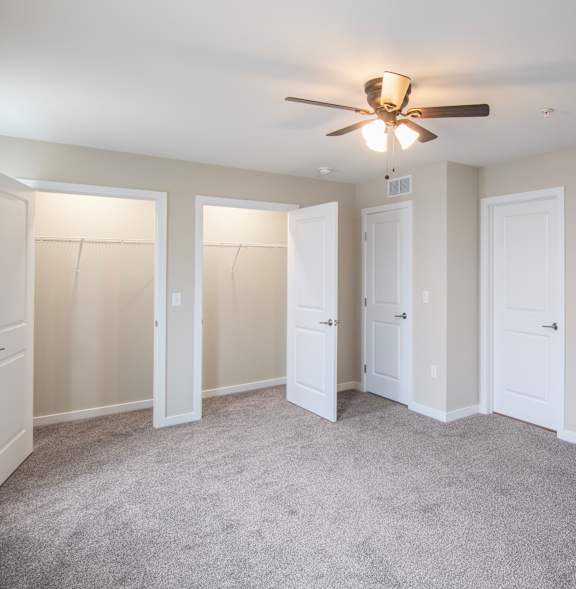 A room with a ceiling fan and a window.