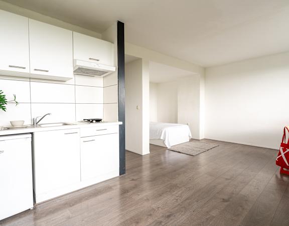 a bedroom with a bed and a desk and a window