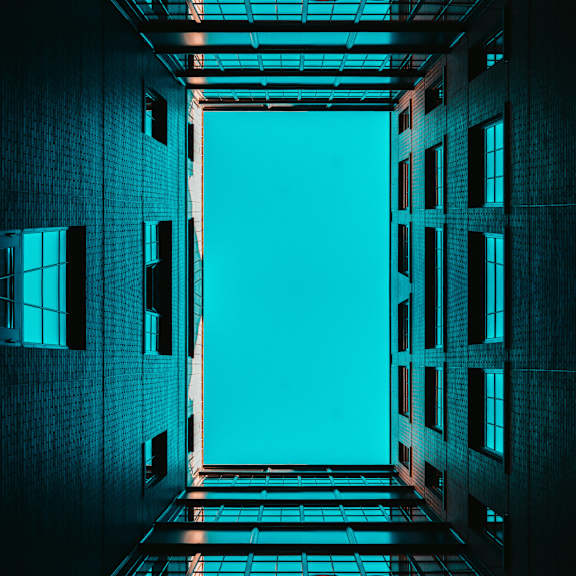 the light at the end of a building corridor with the blue sky in the background