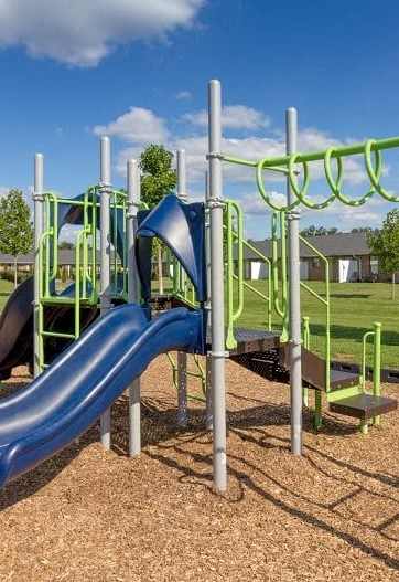 a playground with a blue slide at a park