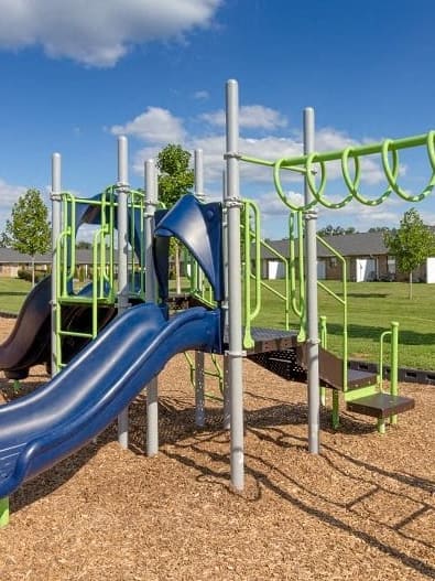 a playground with a blue slide at a park