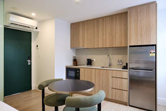 A kitchen with a table and chairs.