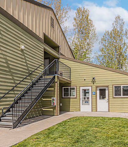 the front of a house with a yard and a building
