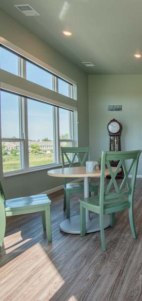A dining room with a round table and chairs.