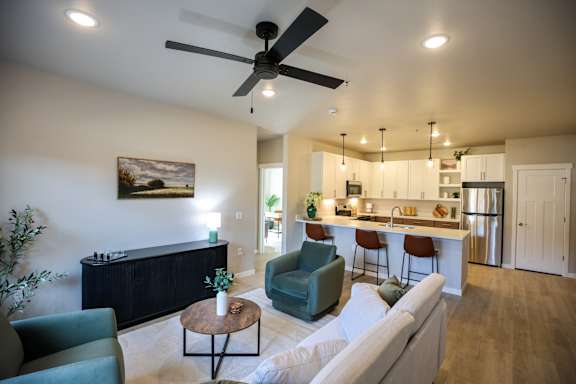 A living room with a ceiling fan and a painting on the wall.