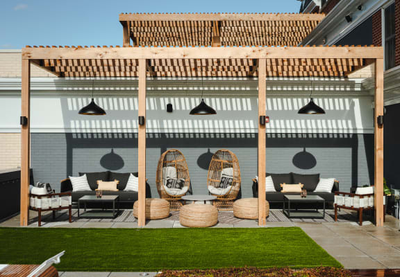 a patio with rattan furniture and a pergola