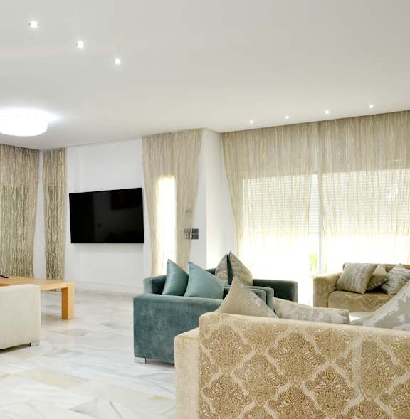 Two beige couches in a room with a door in the background.