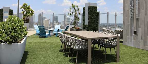 a communal terrace with a table and chairs on a roof top