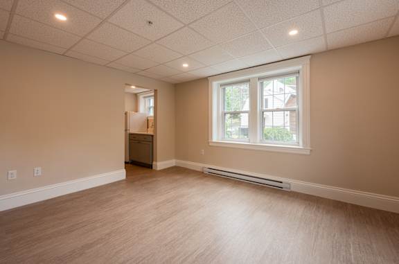A room with a window and a door on the left side.