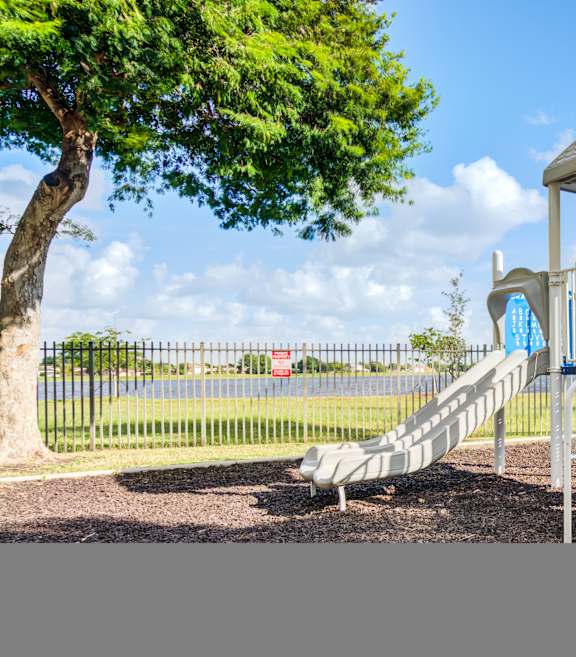 A playground with a white tower structure and a blue slide.