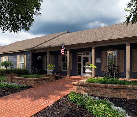 A house with a flag on the porch and a brick pathway leading to the front door at Austin Chase Apartments, Macon, GA 31210