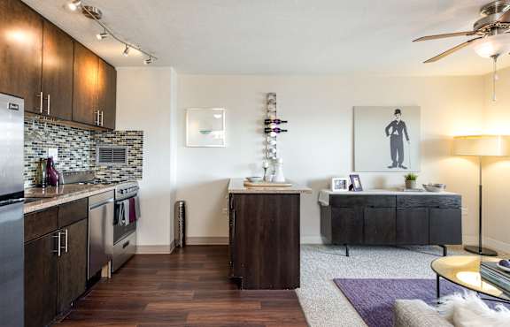 A modern kitchen with dark wood floors and a marble backsplash.