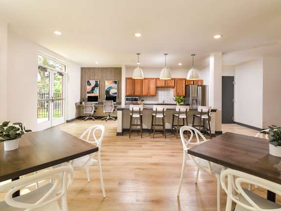 A modern dining room with a wooden table and white chairs.