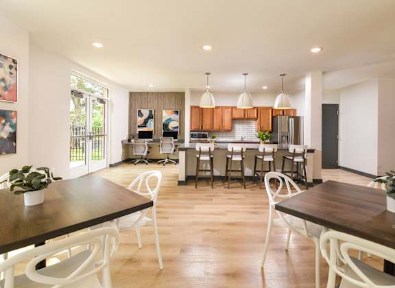A modern dining room with a wooden table and white chairs.