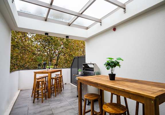 a dining area with a wooden table and chairs and a large window