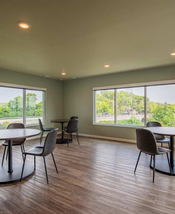 A room with a table and chairs and a clock on the wall.