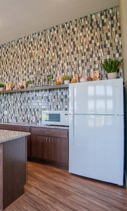 A kitchen with a white refrigerator and wooden floors.