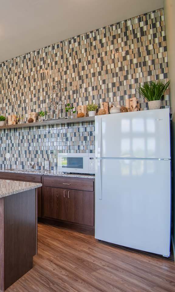 A kitchen with a white refrigerator and wooden floors.