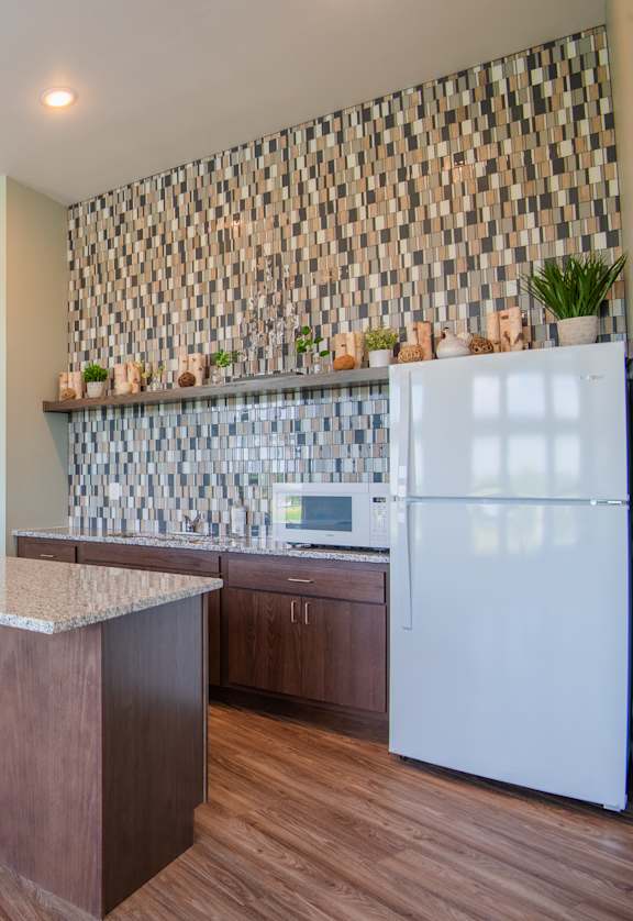 A kitchen with a white refrigerator and wooden floors.