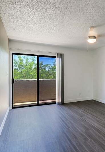 A room with a sliding glass door leading to a backyard.