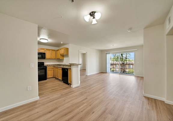 A kitchen with wooden floors and a ceiling fan.
