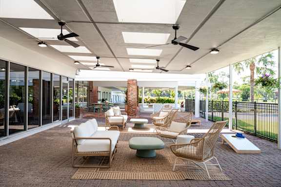 A patio with a table and chairs and a fan.