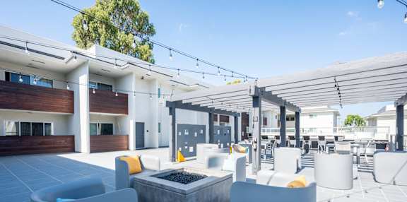a view of the patio area of the building with couches and chairs and a firepit  at Bixby Hill Apartments, Long Beach, CA
