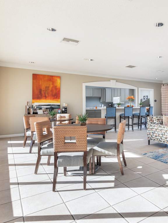 A spacious living room with a dining area and a kitchen in the background.