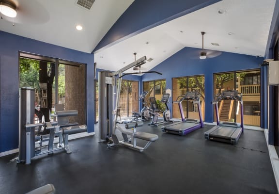 a gym with exercise equipment and windows