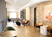 Thumbnail 3 of 9 - A room with a brick wall and a painting of a person wearing a hat. at District on the Etowah Apartments, Canton