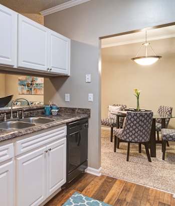 A kitchen with white cabinets and a black refrigerator at Austin Chase Apartments, Georgia