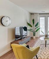 A living room with a yellow chair and a television.