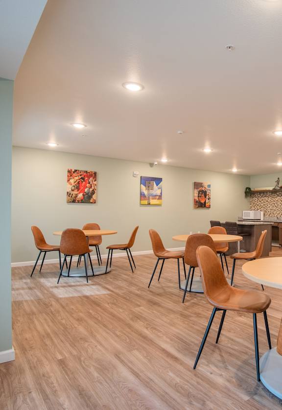 A room with a table and chairs and a framed jersey on the wall.