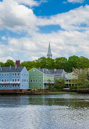 A row of colorful houses sits on the shore of a lake.