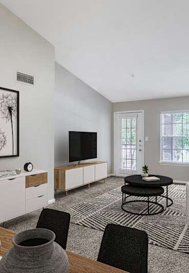 A modern living room with a dining table set for two.