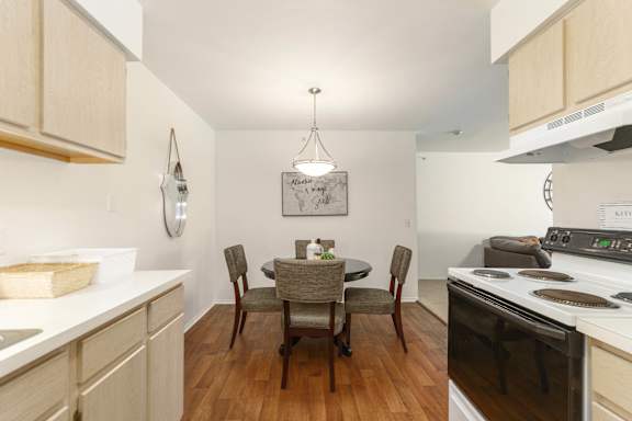A kitchen with a table and chairs in the middle.