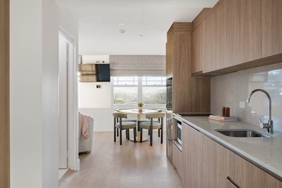 A modern kitchen with a dining table and chairs.